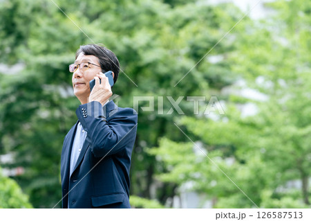 屋外でスマホ通話するビジネスマン 126587513