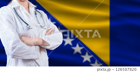 Doctor with crossed arms on Bosnia flag. Bosnia health and care concept. Female doctor on Bosnia flag 126587820