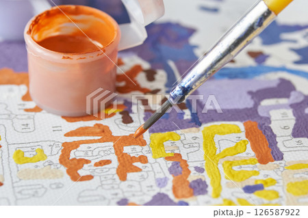 Close up of paint by numbers kit with brush and paint pots in vibrant colors 126587922