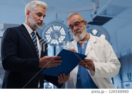 Doctor signing contract with pharmaceutical representative. 126588980