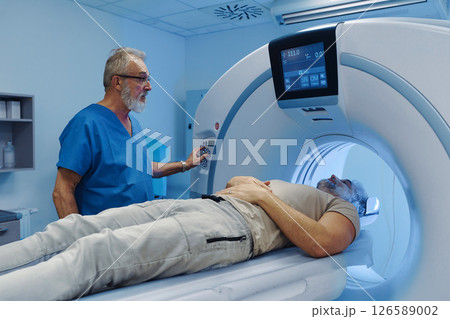 Male patient undergoing CT scan examination in hospital. Male patient undergoing CT scan examination in hospital. 126589002