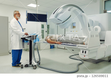 Male patient undergoing CT scan examination in hospital. Male patient undergoing CT scan examination in hospital. 126589011