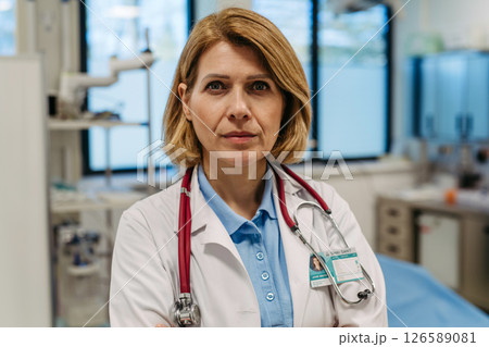 Portrait of female doctor standing in examination room. 126589081