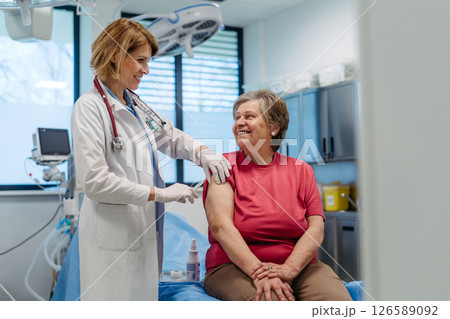 Elderly patient being vaccinated by doctor. Elderly patient being vaccinated by doctor. 126589092