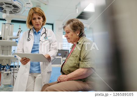 Geriatrician talking about test results with senior patient during check-up. 126589105