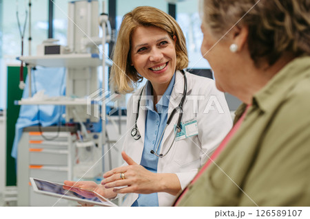 Geriatrician talking about test results with senior patient during check-up. 126589107