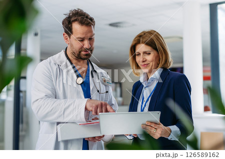 Female medical sales representative presenting medication to doctor Female medical sales representative presenting medication to doctor 126589162