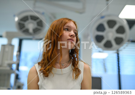 Teenage girl waiting for medical examination in hospital. Teenage girl waiting for medical examination in hospital. 126589363
