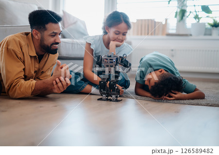 Father teaching kids about STEM, robotics, and discussing technology. 126589482