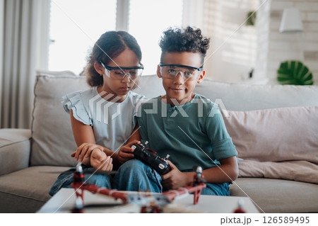 Kids playing with drone at home. 126589495