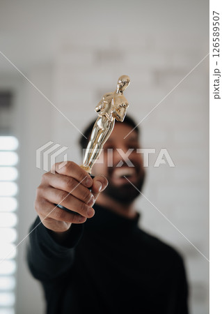 Smiling young engineer holding robotic arm. Smiling young engineer holding robotic arm. 126589507
