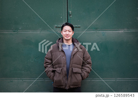 Portrait of young handsome Asian man outdoors during cold day. 126589543