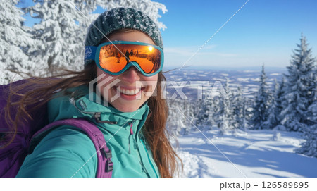 Smiling Woman Hiking in Snowy Mountains Taking a Winter Selfie 126589895