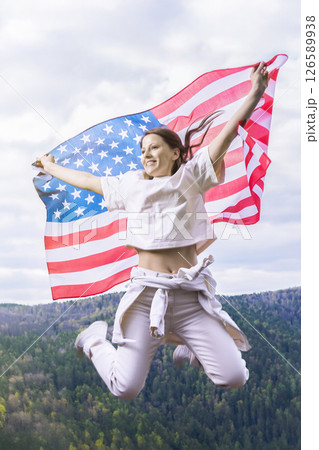 Young woman with American flag on the beach. Patriotic holiday. USA celebrate 4th of July. Independence Day concept 126589938