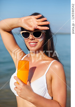 Summer Skincare Routine on the Beach With Sunscreen Application to Protect Against UV Rays 126590542