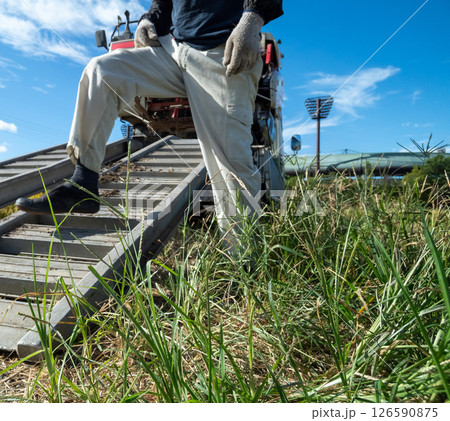 コンバインをトラックから降ろす 126590875