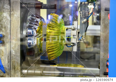 The plastic blow parts gripping by vacuum robotic arm from injection machine. 126590974