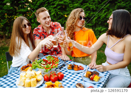 Happy friends in picnic in park. Friends grill meat, have fun, relax. ?oncept of holidays, weekends. Happy friends in picnic in park. Friends grill meat, have fun, relax. ?oncept of holidays, weekends. 126591170