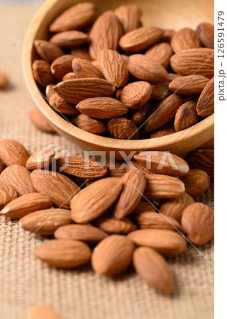 Raw almond nut seed in wooden bowl 126591479