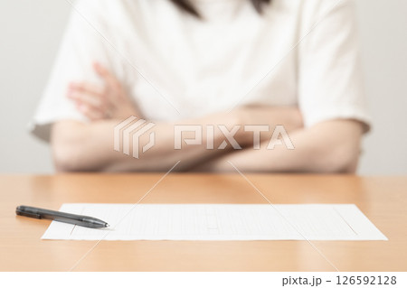 原稿用紙の前で腕組みをする女性のイメージ (写真素材) 原稿用紙の前で腕組みをする女性のイメージ (写真素材) 126592128