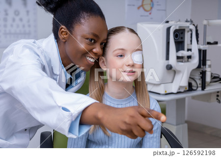 Girl having an exam at the ophthalmologist office and looking positive Girl having an exam at the ophthalmologist office and looking positive 126592198