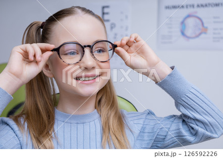Cute caucasian girl in eyeglasses looking positive and contented Cute caucasian girl in eyeglasses looking positive and contented 126592226