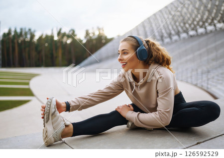 Strong woman doing exercises outdoors in the morning. Active life, healthy lifestyle. Strong woman doing exercises outdoors in the morning. Active life, healthy lifestyle. 126592529
