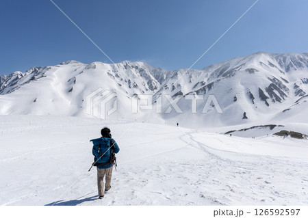 立山連峰と春の雪景色の中、男性がトレッキングをしている 立山連峰と春の雪景色の中、男性がトレッキングをしている 126592597