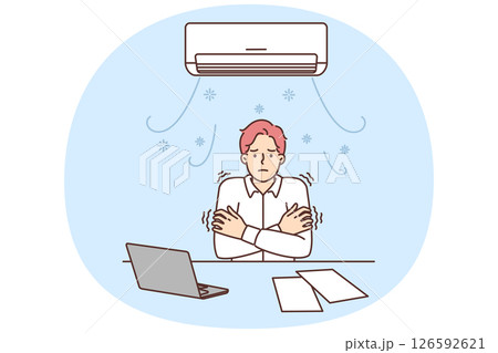 Man sitting at office desk under air conditioner freezes due to cold temperatures 126592621