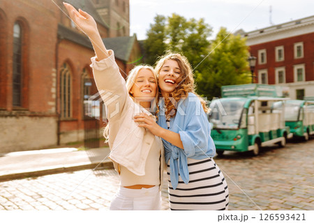 Two beautiful women are walking down the street. Fun and walking concept. Active lifestyle. 126593421