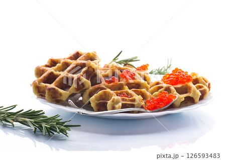Delicious potato waffles with red caviar on a white background Delicious potato waffles with red caviar on a white background 126593483