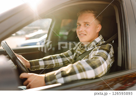 Happy man feeling comfortable sitting on driver seat in car. Lifestyle concept. Car sharing concept. Happy man feeling comfortable sitting on driver seat in car. Lifestyle concept. Car sharing concept. 126593893