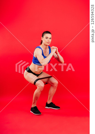 Athletic female performs exercises using a resistance band. Strength and motivation 126594328