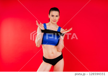Athletic female performs exercises using a resistance band. Strength and motivation 126594331