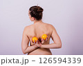 Naked woman back with an orange fruit the isolated image 126594339
