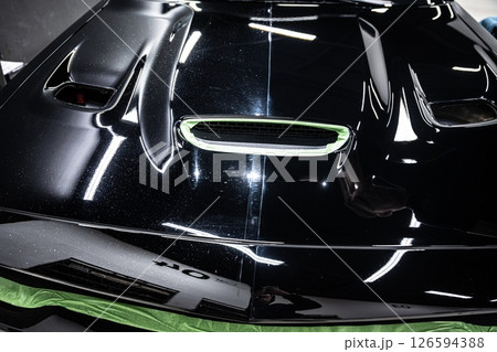 Car hood showing before and after paint correction 126594388