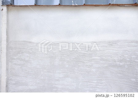 Concrete plastering wall and scrate surface to prepare for tile installation. 126595102