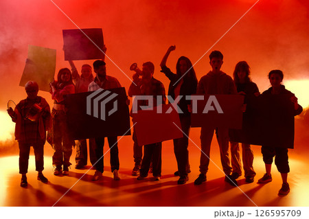 Protesters in red light wit fog hold posters and shout together. Some raise fists, others bang pots. Emergency demonstration 126595709