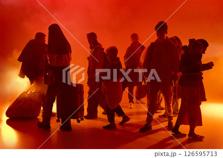 Silhouettes of people in red neon light, looks as fire, and fog carry bags and luggage in different directions. Crisis and stress. Silhouettes of people in red neon light, looks as fire, and fog carry bags and luggage in different directions. Crisis and stress. 126595713