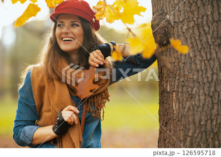 smiling young woman in jeans shirt and red hat 126595718