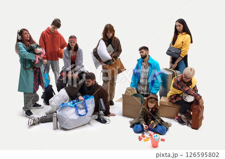 Mixed group of tired people with luggage and pillows in studio setting showing exhaustion and confusion 126595802