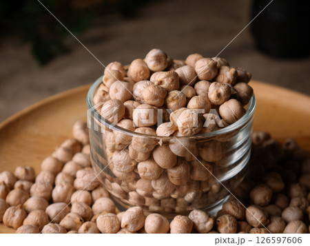 Raw Chickpeas on a rustic wooden table. Dry chickpea background close up. Chickpea legumes seed background. Raw Chickpeas on a rustic wooden table. Dry chickpea background close up. Chickpea legumes seed background. 126597606