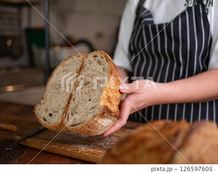 Artisan Sourdough Bread in Hand - Fresh from the Oven. Artisan Sourdough Bread in Hand - Fresh from the Oven. 126597608