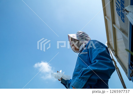 稲刈りをする農家 稲刈りをする農家 126597737