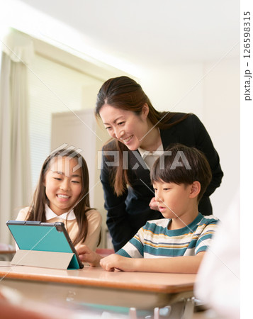 タブレットを使う小学生と指導する先生 126598315