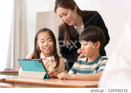 タブレットを使う小学生と指導する先生 126598316