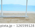 夏の海辺の砂浜と白いロープの木製ブランコ 126599128