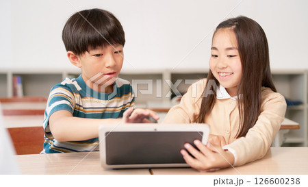 一緒にタブレットの画面を見る小学生の男女 126600238