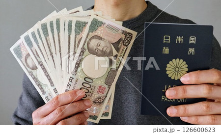 日本のパスポートと紙幣を持つ人物 126600623