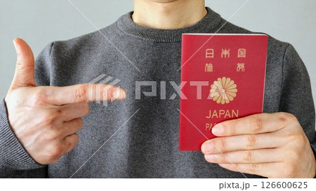 パスポートを持ち指差す人物 パスポートを持ち指差す人物 126600625